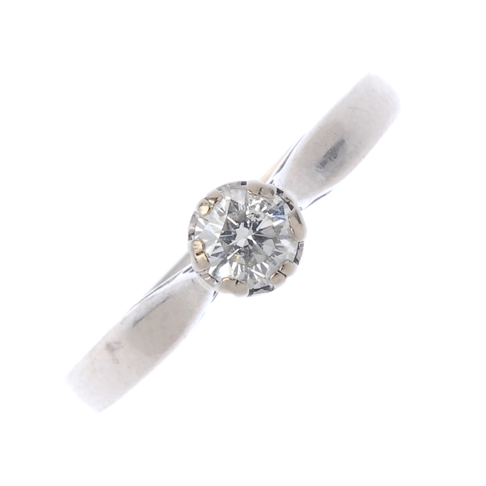 An 18ct gold diamond single-stone ring. The brilliant-cut diamond, to the tapered shoulders and