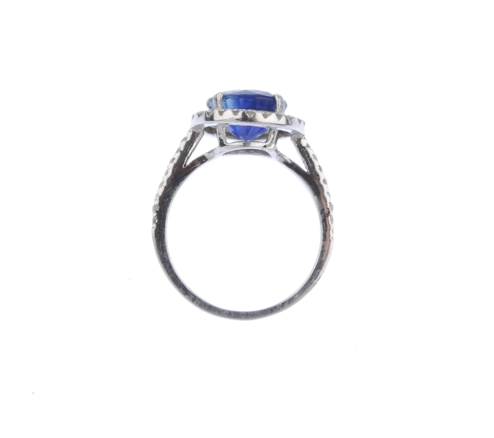 (539356-2-A) A sapphire and diamond cluster ring. The circular-shape sapphire, with brilliant-cut - Image 2 of 4