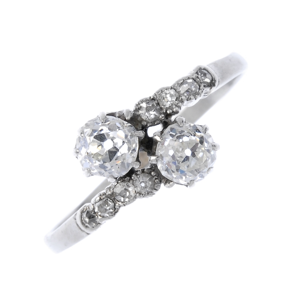 An early 20th century diamond two-stone crossover ring. The old-cut diamond asymmetric terminals,