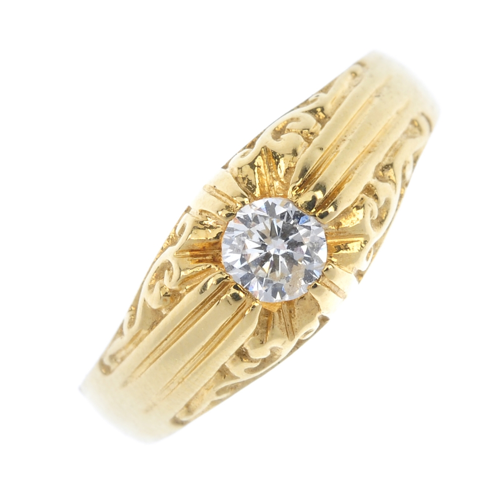 An 18ct gold diamond single-stone ring. The brilliant-cut diamond, to the scrolling sides and