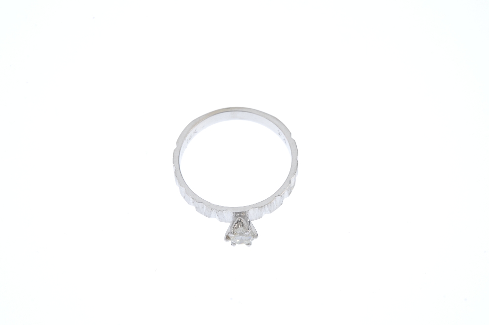 A diamond single-stone ring. The brilliant-cut diamond, to the textured sides and plain band. - Image 2 of 4