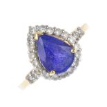 A coated tanzanite and diamond cluster ring. The pear-shape coated tanzanite, within a brilliant-cut