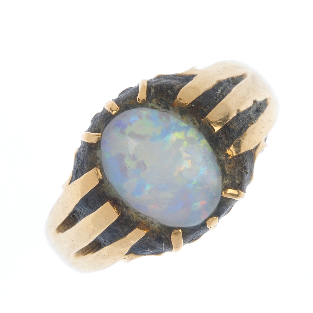 A gentleman's early 20th century 18ct gold opal ring. The oval opal cabochon, within an extended