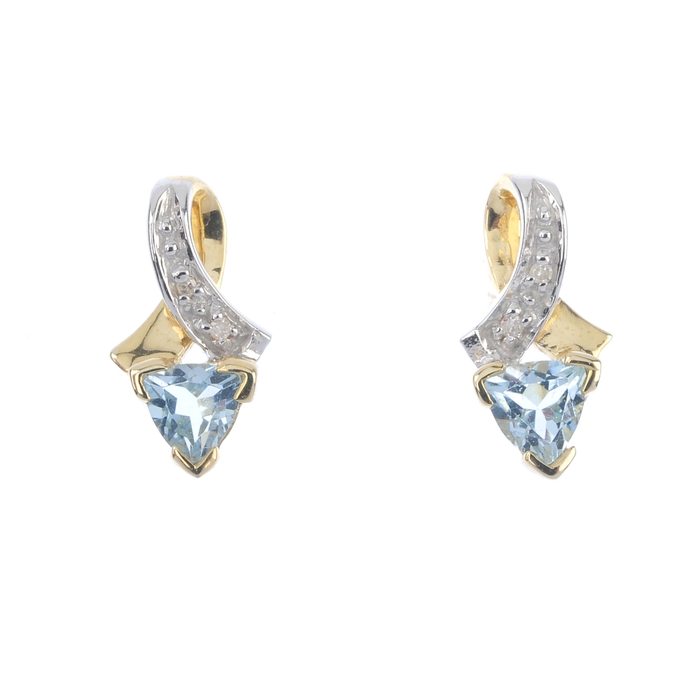 A pair of topaz and diamond ear pendants. Each designed as a triangular-shape topaz, to the single-