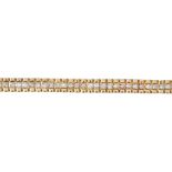 A 9ct gold diamond bracelet. Of bi-colour design, the brilliant-cut diamond line, to the polished