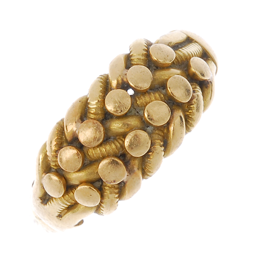 An Edwardian 18ct gold keeper ring. Of interwoven design, with bead accents, to the plain band.