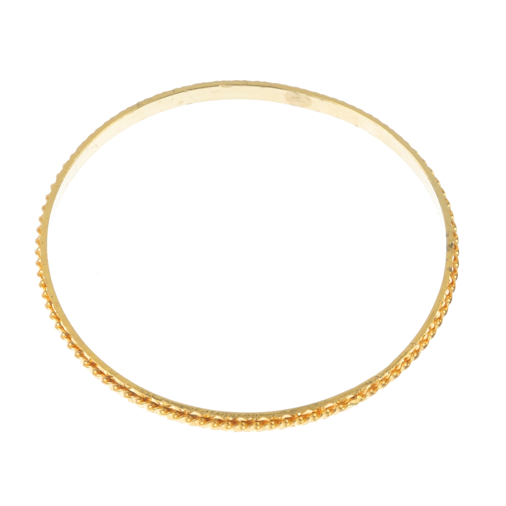A 22ct gold bangle. Of spiral and bright-cut design. Hallmarks for London, 2007. Inner diameter 6.