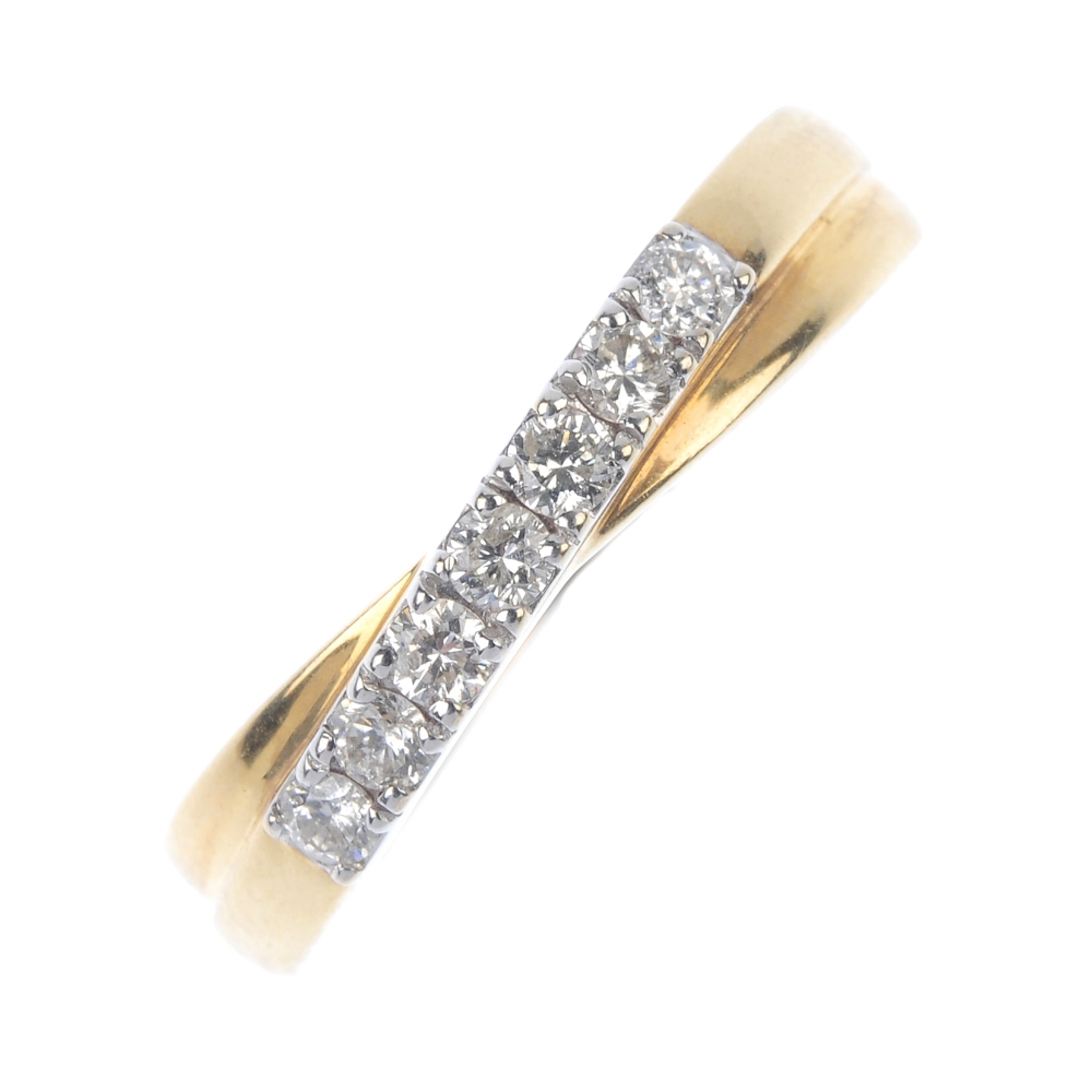 An 18ct gold diamond crossover band ring. The brilliant-cut diamond line crossover centre, to the