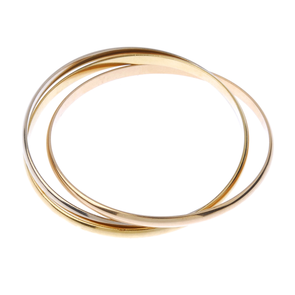 (544516-7-A) CARTIER - a 'trinity' bangle. Comprising three, tri-colour, interwoven bangles.