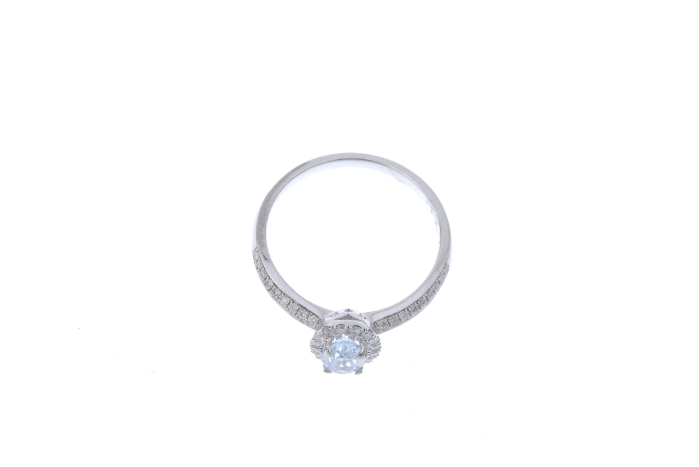 An aquamarine and diamond dress ring. The oval-shape aquamarine, within a brilliant-cut diamond - Image 2 of 4