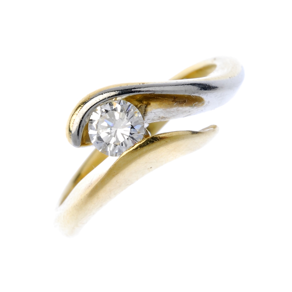 A diamond crossover ring. Of bi-colour design, the brilliant-cut diamond, to the asymmetric
