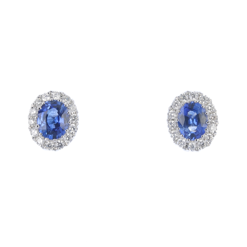 * A pair of sapphire and diamond cluster ear studs. Each designed as an oval-shape sapphire,