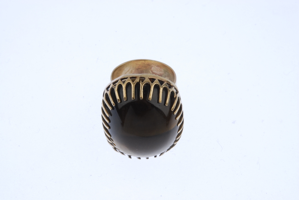 A 1970s 9ct gold tiger's eye dress ring. The cushion-shape tiger's eye cabochon, within an elongated - Image 2 of 4