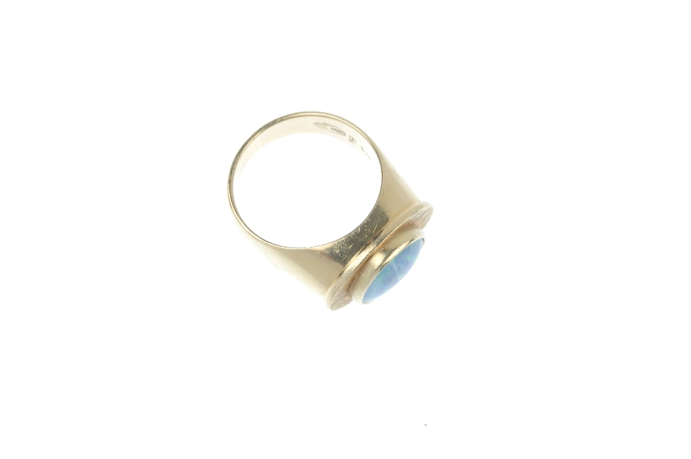 An opal triplet ring. The oval opal triplet, within a textured surround, to the tapered shoulders. - Image 3 of 4