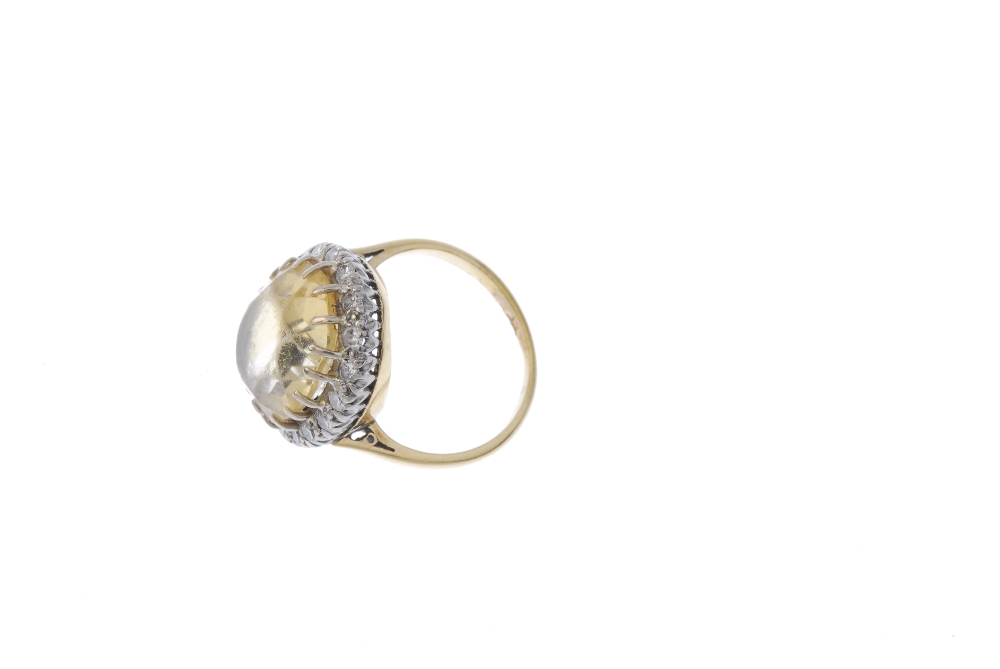 A citrine and diamond cluster ring. The oval-shape citrine, within a brilliant-cut diamond surround, - Image 3 of 4