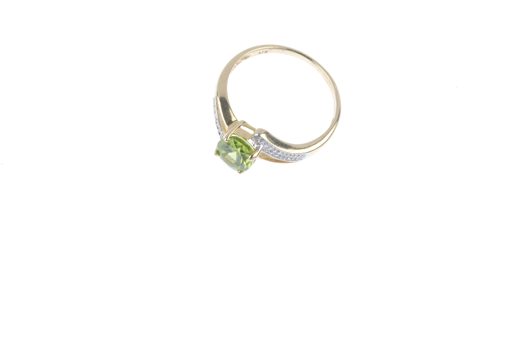 A 9ct gold peridot and diamond crossover ring. The oval-shape peridot, to the single-cut diamond - Image 2 of 4