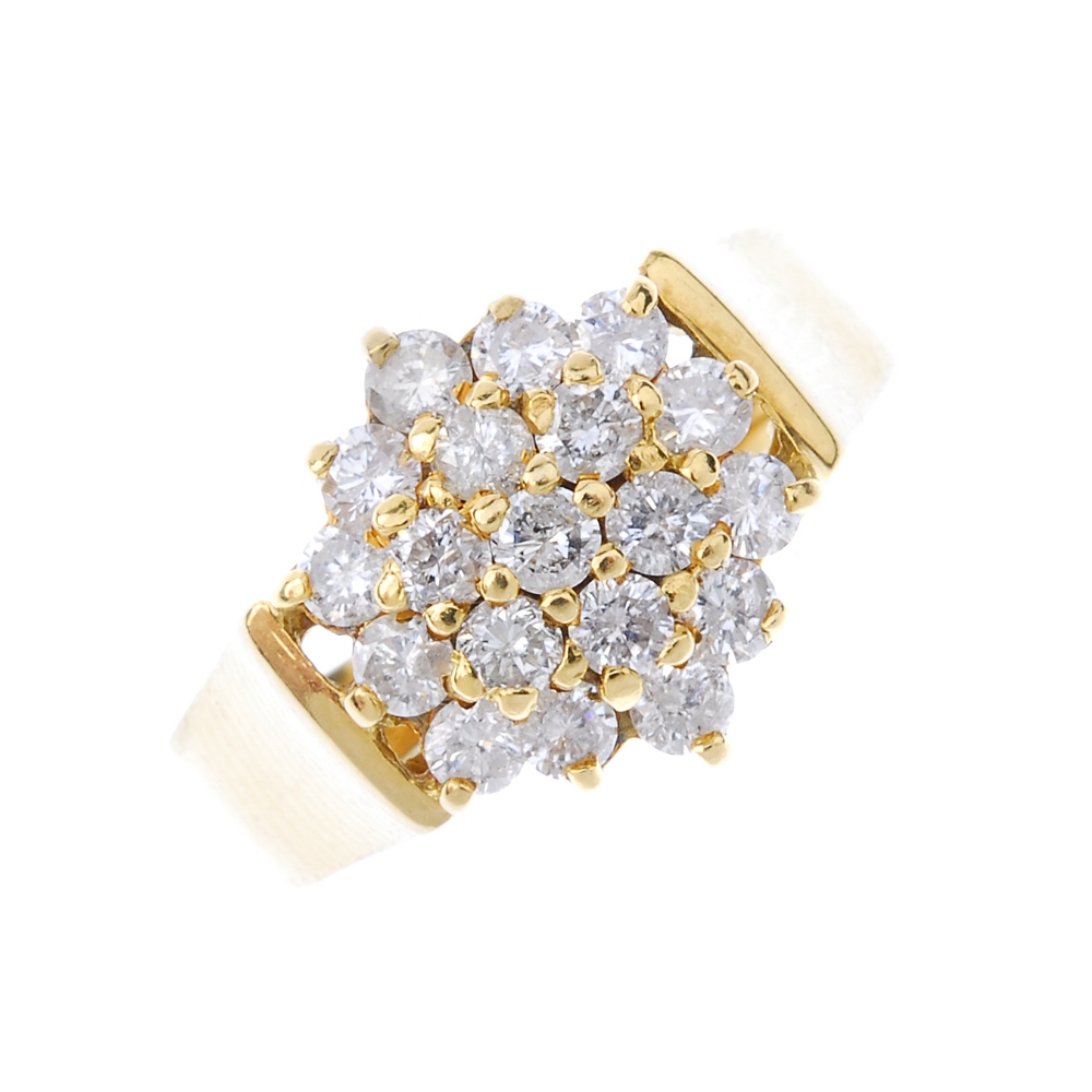 An 18ct gold diamond cluster ring. The brilliant-cut diamond stepped cluster, to the plain band.