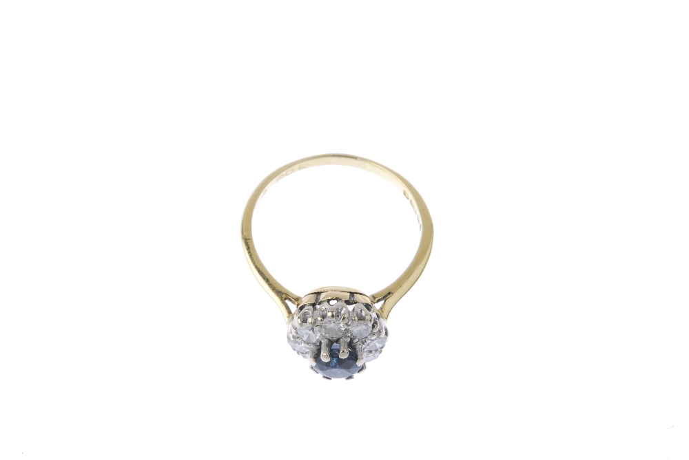 An 18ct gold sapphire and diamond cluster ring. The circular-shape sapphire, within a brilliant- - Image 2 of 4