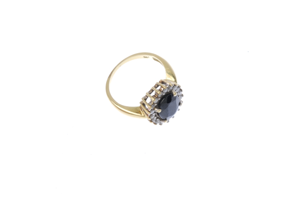 A sapphire and diamond cluster ring. The oval-shape sapphire, within a brilliant-cut diamond - Image 3 of 4