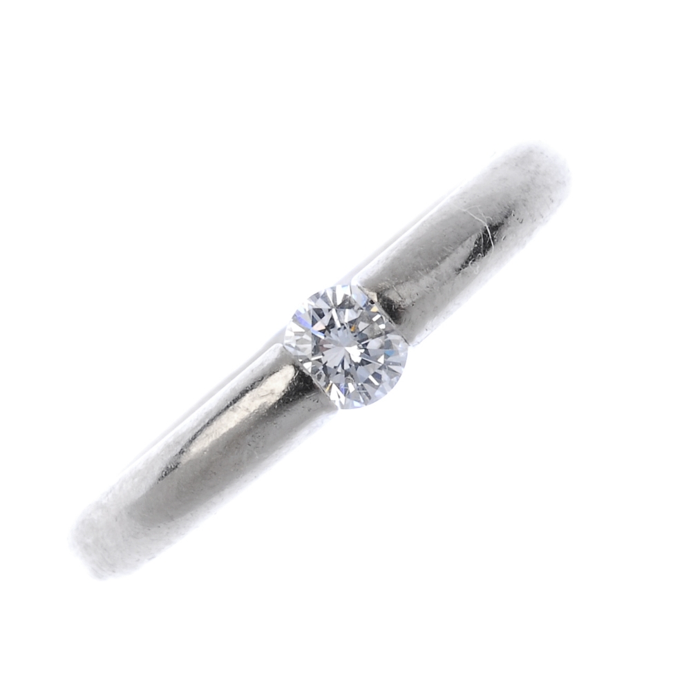 A diamond single-stone ring. The brilliant-cut diamond, to the plain band. Estimated diamond