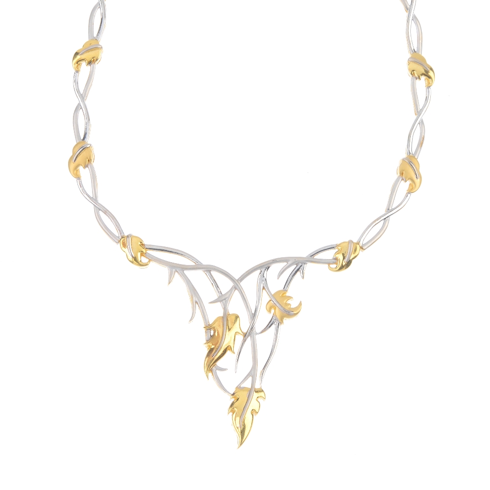 A foliate necklace. Of bi-colour design, the interwoven foliate panel, suspended by similarly-
