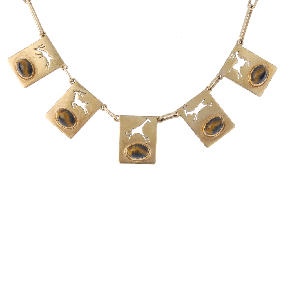 A tiger's-eye novelty necklace. Of African design, the front designed as a series of rectangular-