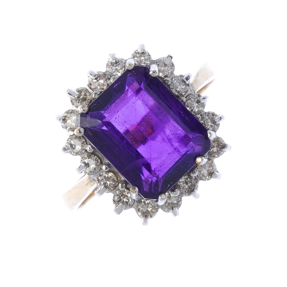 A 9ct gold amethyst and diamond cluster ring. The square-shape amethyst within a brilliant-cut