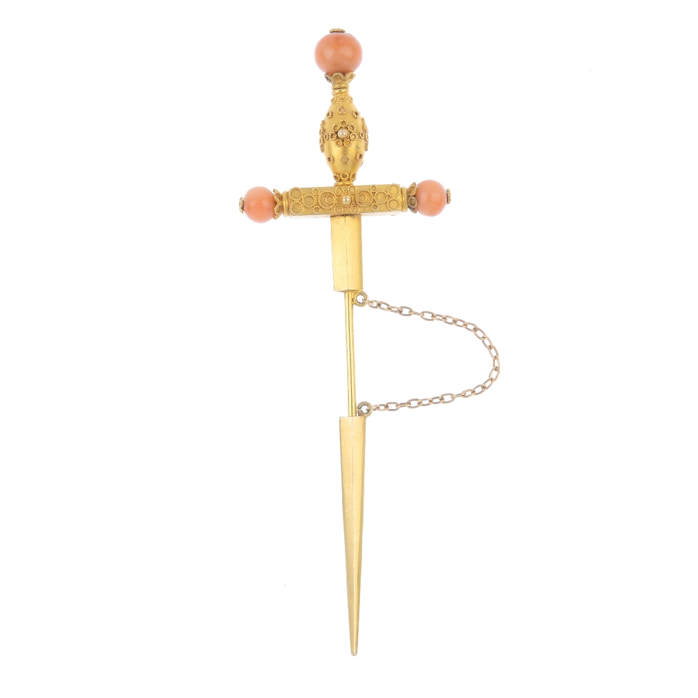 A late 19th century gold coral set stickpin. Designed as a sword with cannetille detail to the