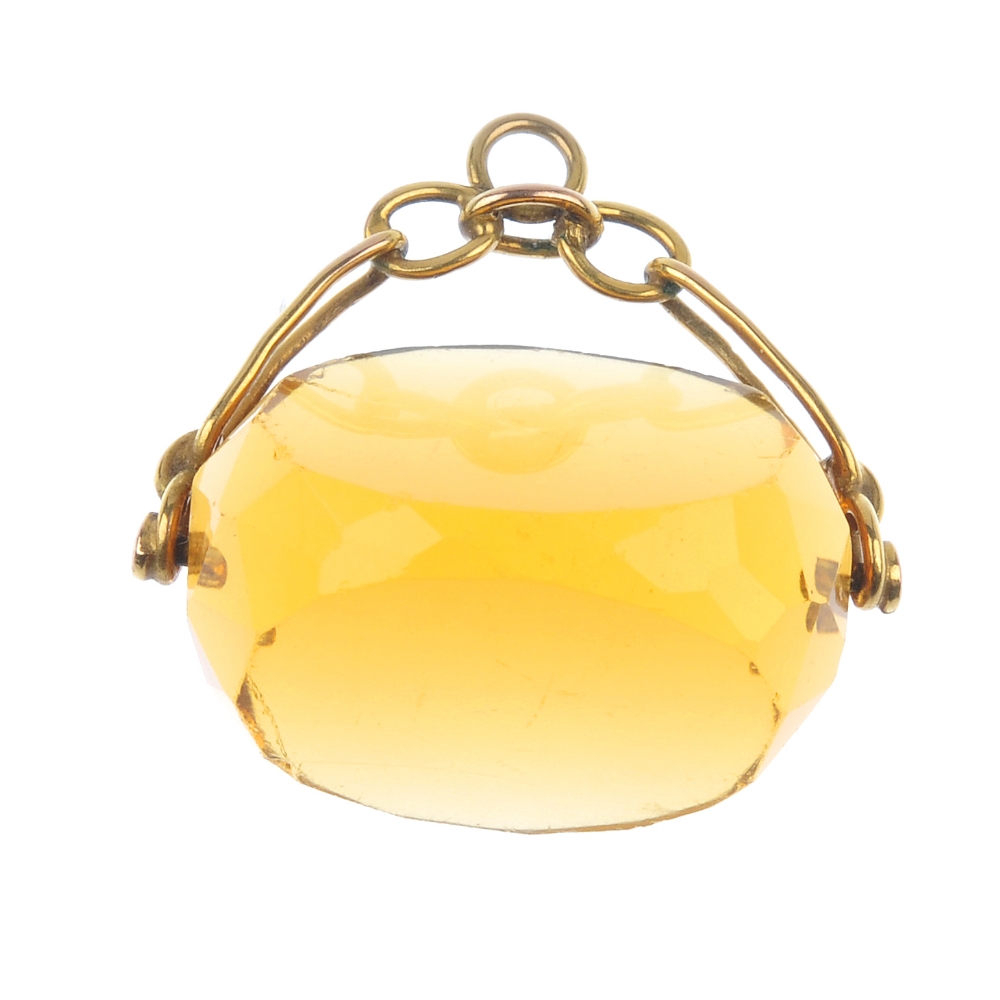 An early 20th century 9ct gold paste swivel fob. The faceted orange paste to the 9ct gold
