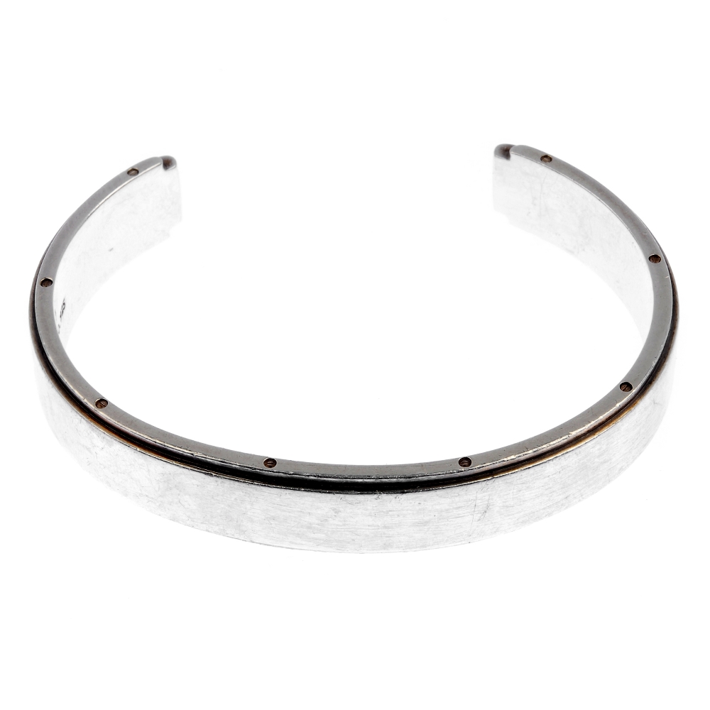 TIFFANY & CO. - a bangle. The open bangle with screw detail to the edges and plain front. Signed