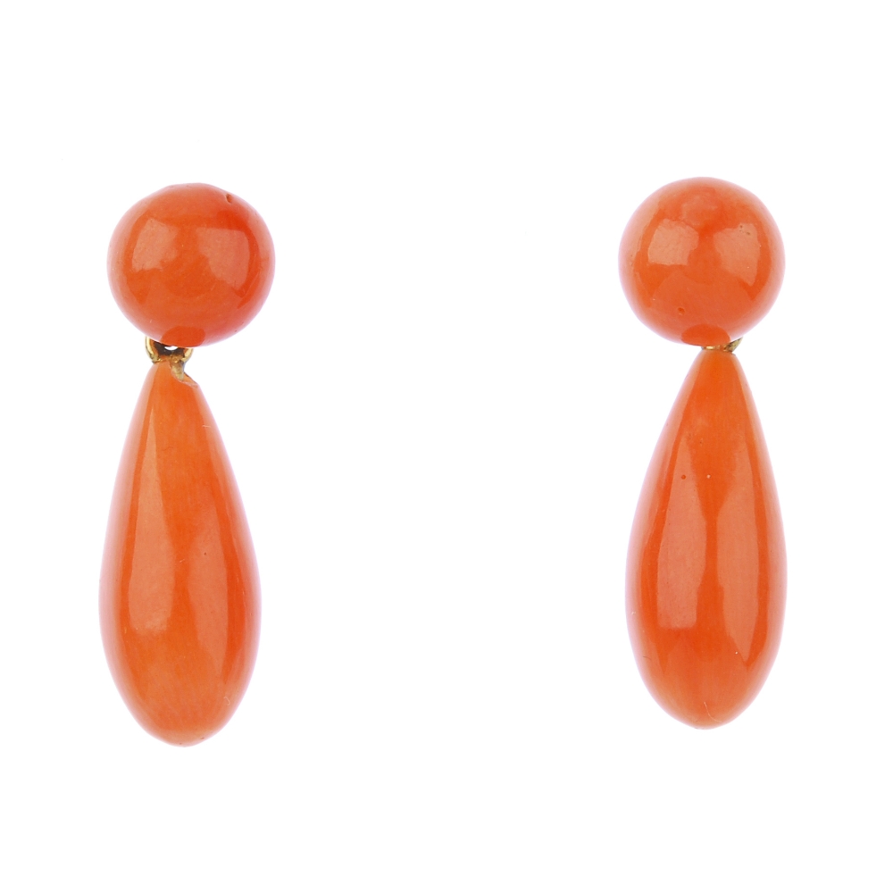 A pair of coral ear pendants. Each designed as a coral drop, suspended from a coral bead surmount.