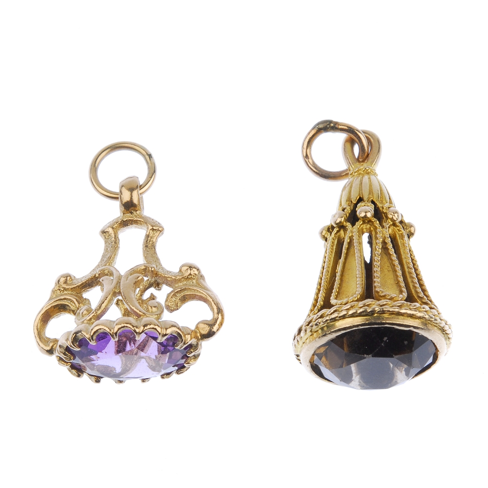 Two 9ct gold gem-set fobs. The first designed as an oval-shape amethyst to the scrolling 9ct gold