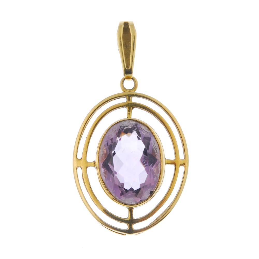 A 9ct gold amethyst pendant. The oval-shape amethyst, within an openwork surround, to the