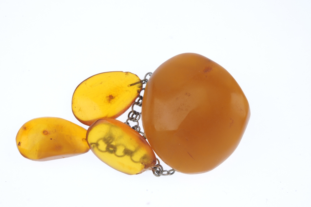 A natural amber brooch. The irregular-shape translucent polished amber panel, suspending three - Image 3 of 3