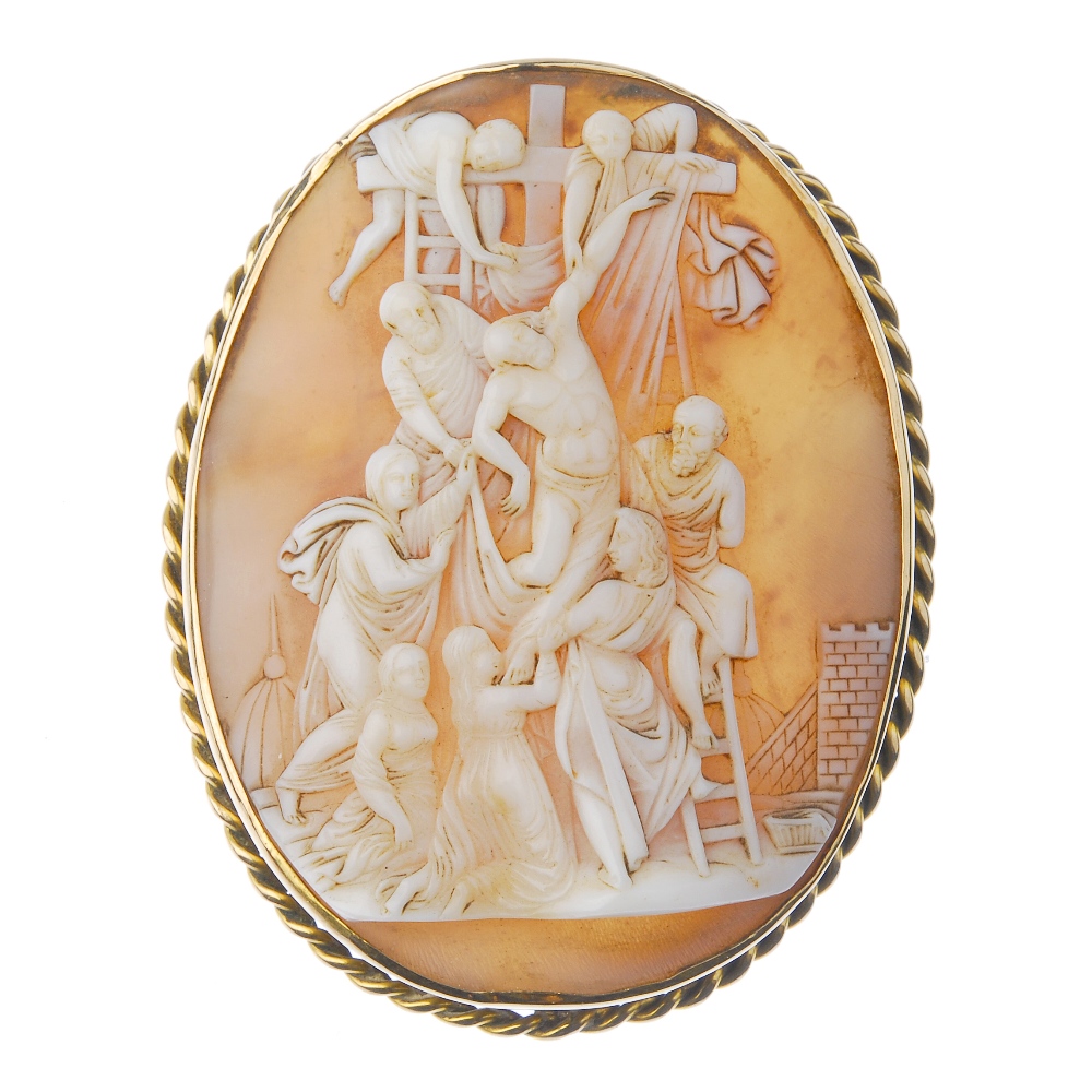 A cameo brooch. Of oval outline, the shell cameo carved to depict Christ's crucifixion, to the