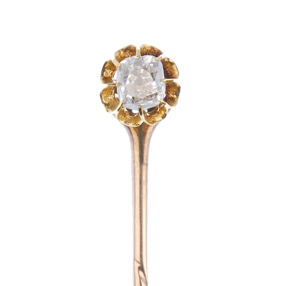 An early 20th century gold diamond stickpin. The old-cut diamond, within an elongated claw