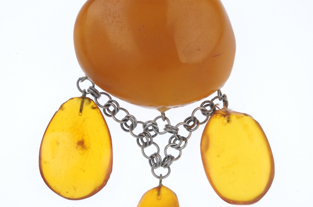 A natural amber brooch. The irregular-shape translucent polished amber panel, suspending three - Image 2 of 3