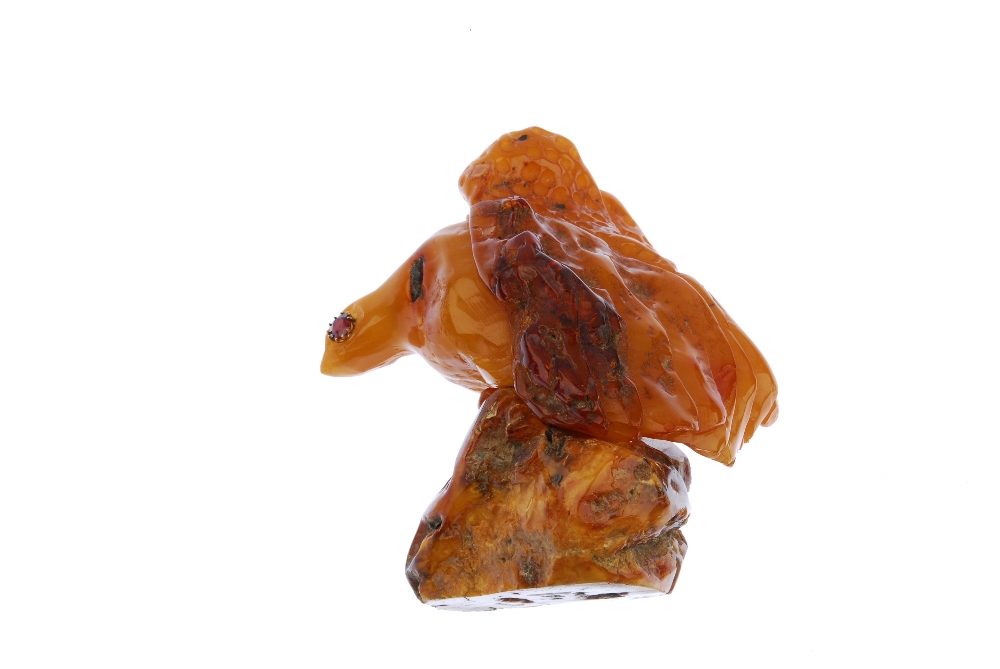 A natural amber ornament. Carved into the form of an eagle, with gem-set eyes, to the freeform - Image 2 of 2