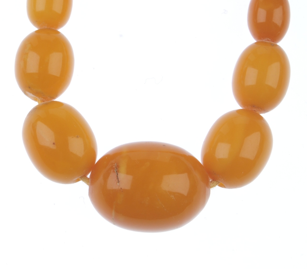 A natural amber necklace. Designed as thirty-five graduated oval-shape beads measuring 8 to 2. - Image 3 of 5