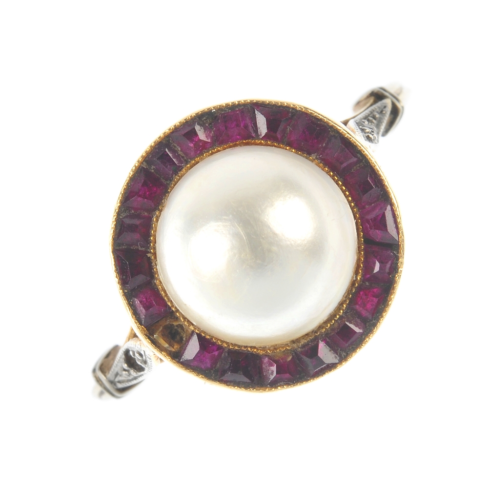 A gem-set ring. The mabe pearl, within a calibre-cut ruby surround, to the diamond point shoulders