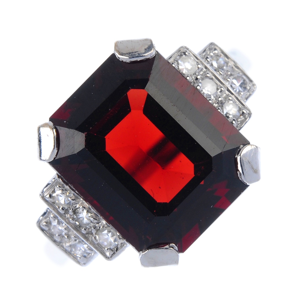 A garnet and diamond dress ring. The rectangular-shape garnet, to the single-cut diamond tiered