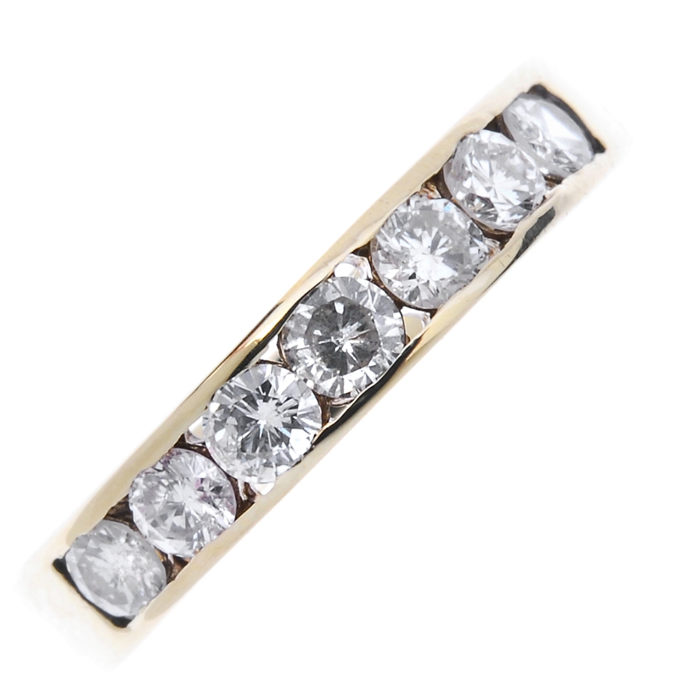 A 9ct gold diamond half-circle eternity ring. The brilliant-cut diamond line, within a channel-
