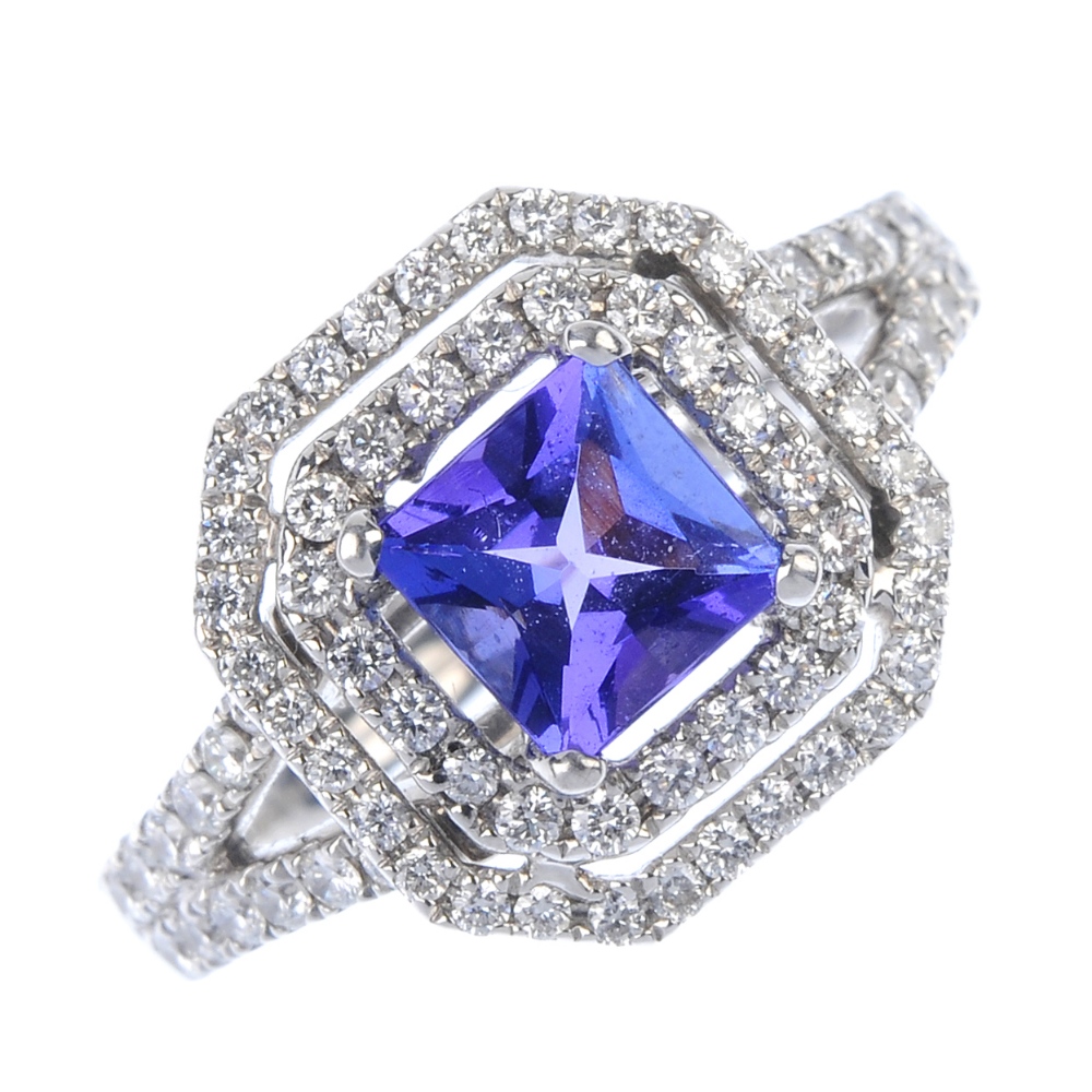 An 18ct gold tanzanite and diamond cluster ring. The square-shape tanzanite, within a brilliant-