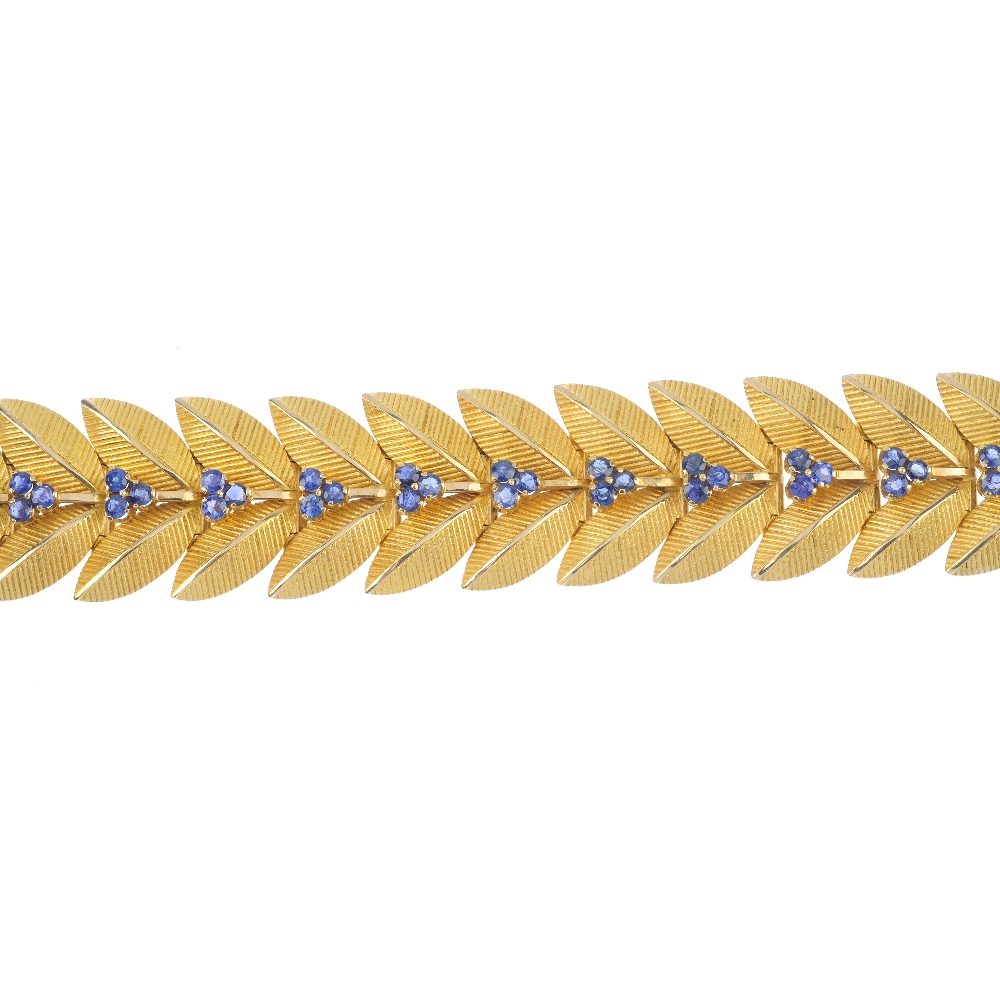 A 1960s 9ct gold sapphire bracelet. Designed as a series of textured twin leaf links, with