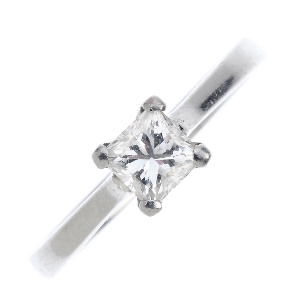 A platinum diamond single-stone ring. The square-shape diamond, weighing 0.55ct, to the tapered