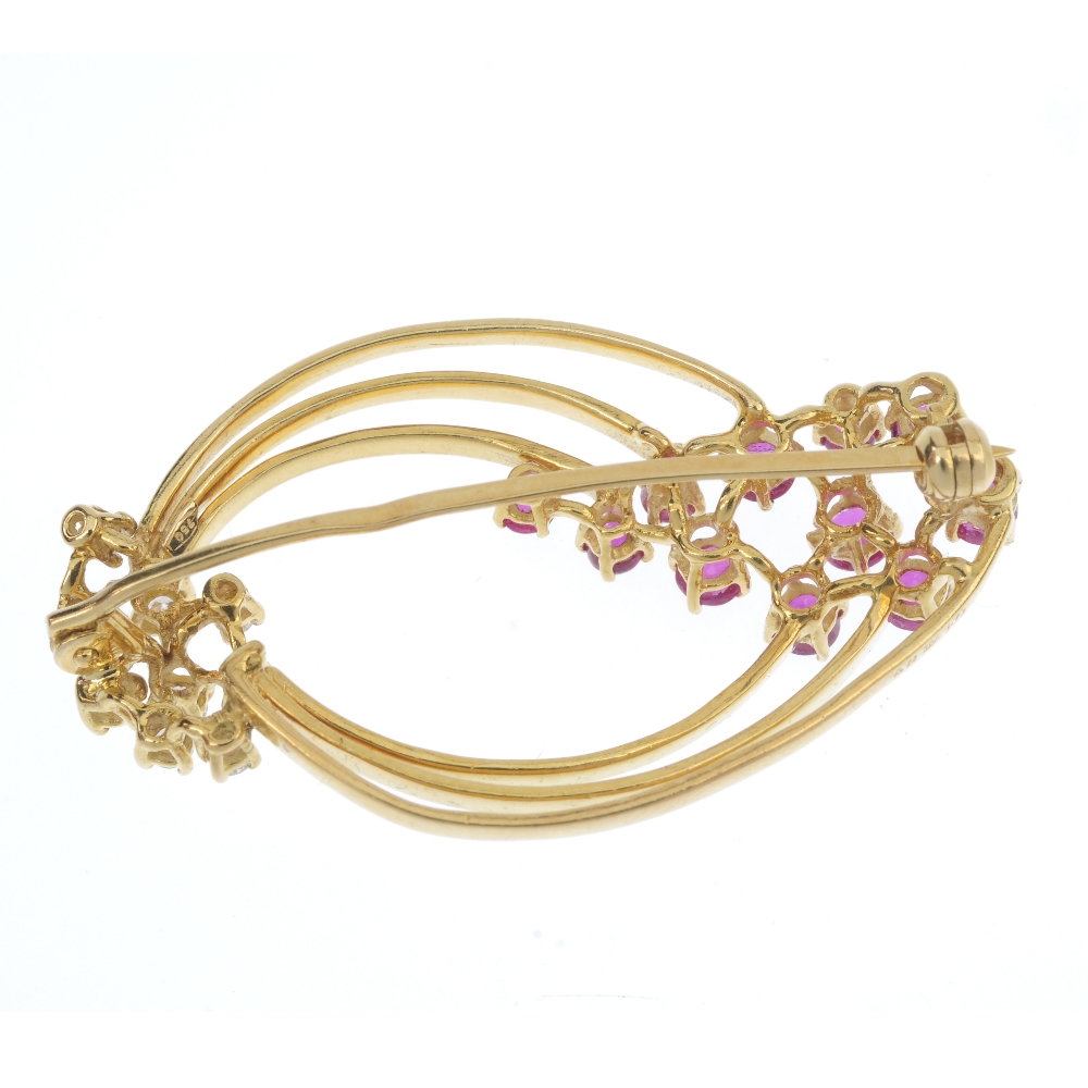 An 18ct gold ruby and diamond brooch. Designed as a series of three tapered hoops, with circular- - Image 2 of 2