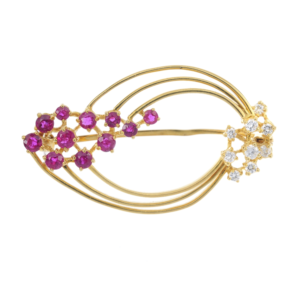 An 18ct gold ruby and diamond brooch. Designed as a series of three tapered hoops, with circular-