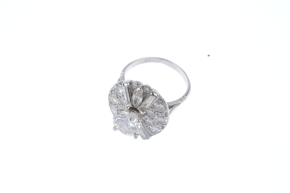 A diamond cluster ring. The brilliant-cut diamond, weighing 2.06cts, raised to the pave-set - Image 2 of 5