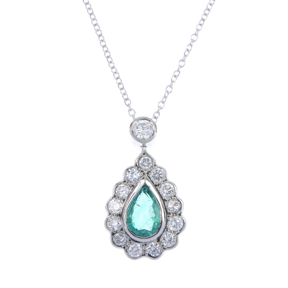 An emerald and diamond cluster pendant. The pear-shape emerald, within a brilliant-cut diamond