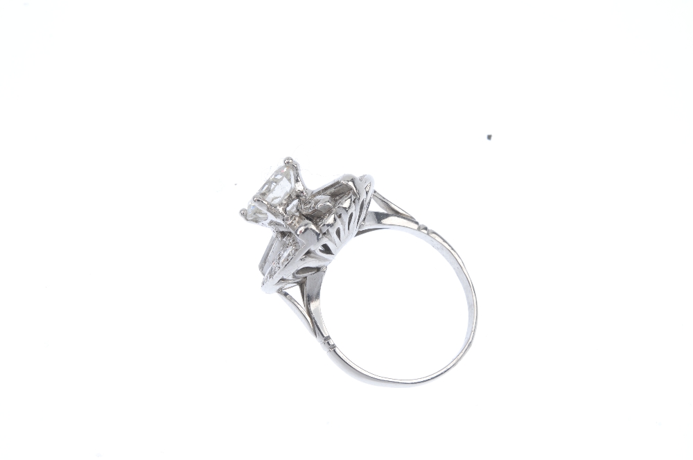 A diamond cluster ring. The brilliant-cut diamond, weighing 2.06cts, raised to the pave-set - Image 3 of 5
